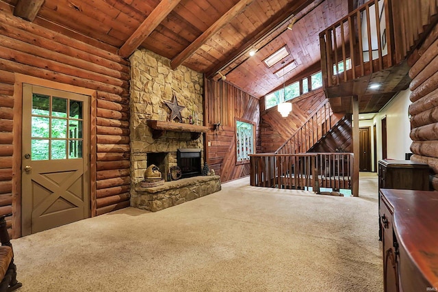 unfurnished living room with rustic walls, wooden ceiling, plenty of natural light, and beam ceiling