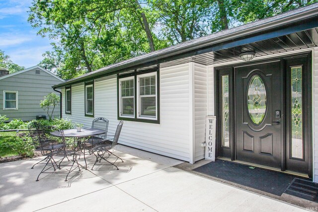 view of exterior entry featuring a patio area