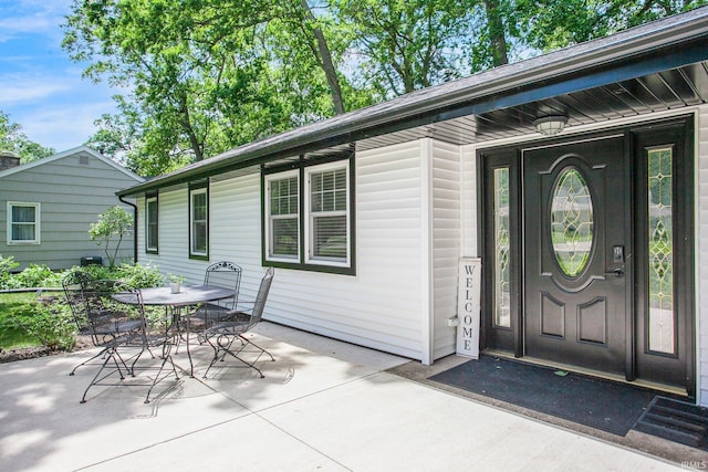 view of exterior entry with a patio