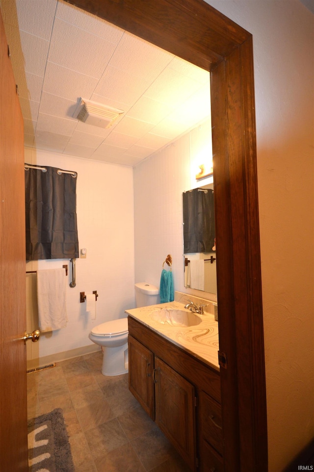 bathroom featuring toilet, vanity, and tile patterned flooring