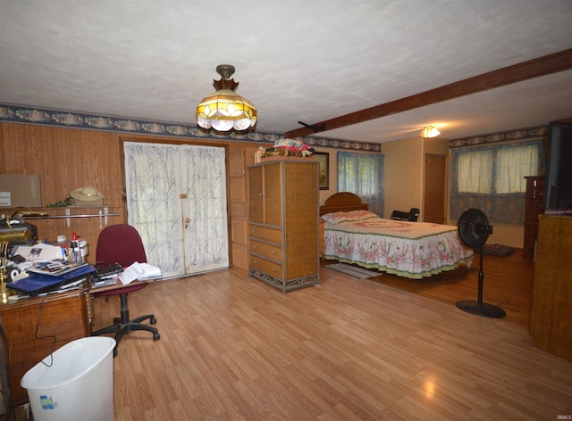 bedroom with beamed ceiling and wood-type flooring