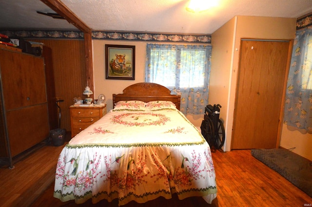 bedroom with a textured ceiling and hardwood / wood-style floors