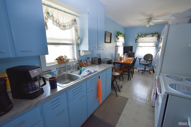 kitchen with white fridge, ceiling fan, sink, and stove