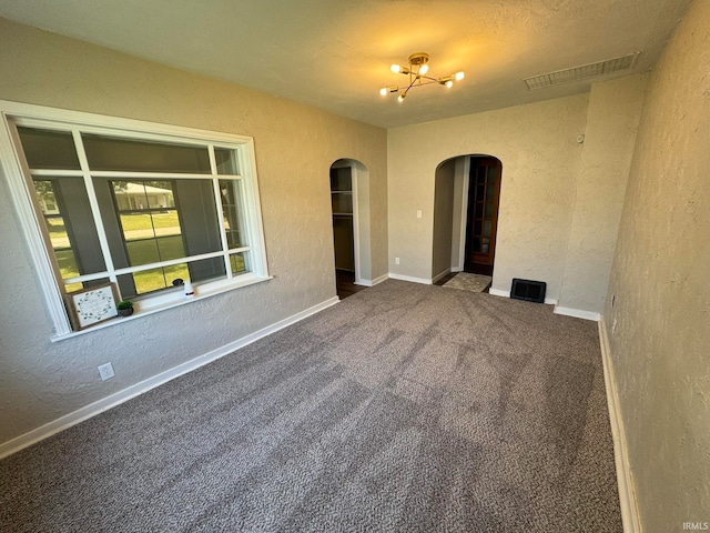 unfurnished room featuring carpet floors and a chandelier