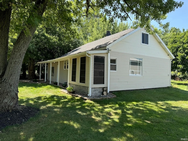 rear view of property featuring a lawn