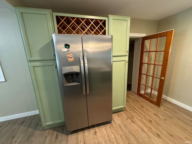 kitchen featuring light hardwood / wood-style flooring, stainless steel refrigerator with ice dispenser, and green cabinets