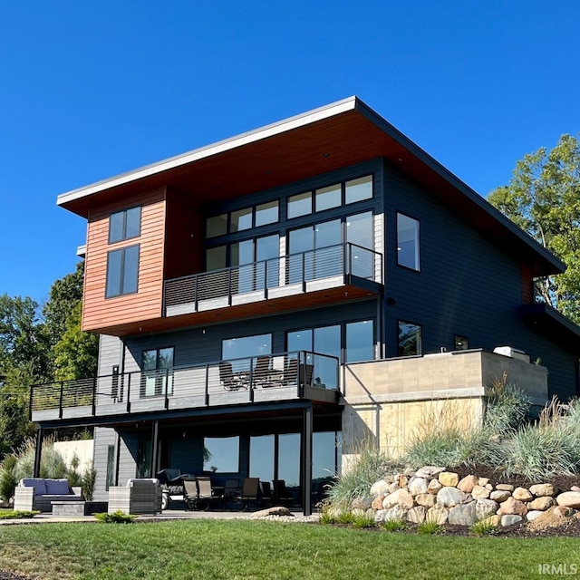 back of property with an outdoor living space, a patio, a balcony, and cooling unit