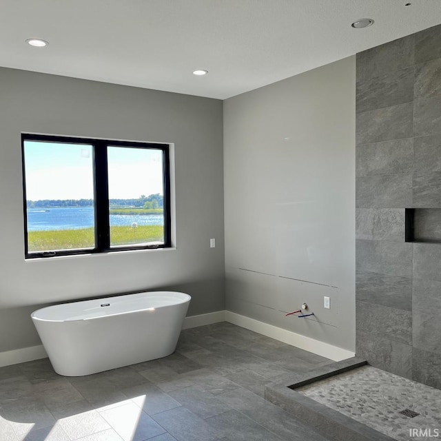 bathroom with a bathing tub and a water view