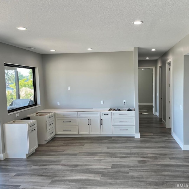 kitchen with white cabinetry, a textured ceiling, light hardwood / wood-style floors, and kitchen peninsula