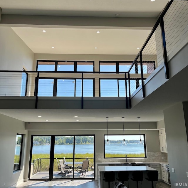 interior space featuring a water view and a towering ceiling