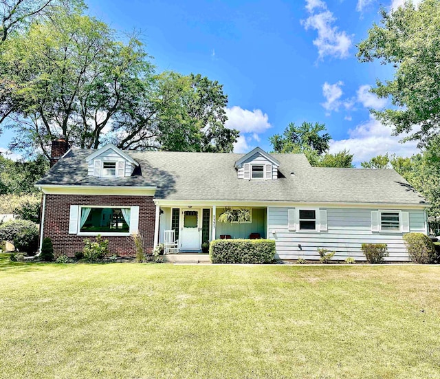 new england style home featuring a front yard and a porch