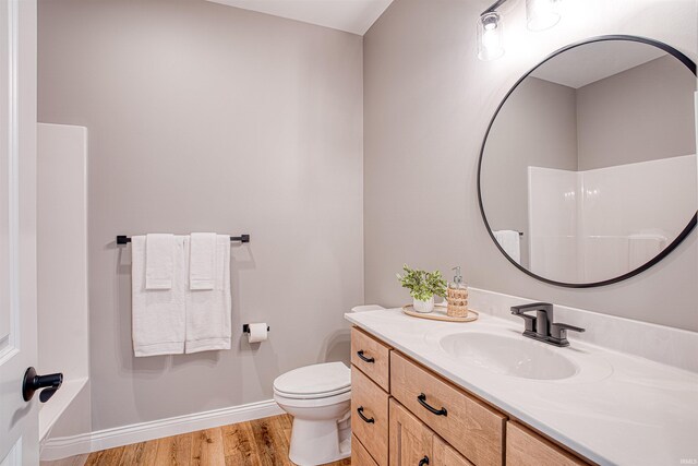 bathroom with walk in shower, wood-type flooring, toilet, and vanity