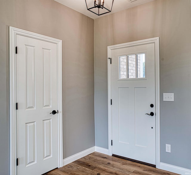 foyer featuring an inviting chandelier and wood-type flooring