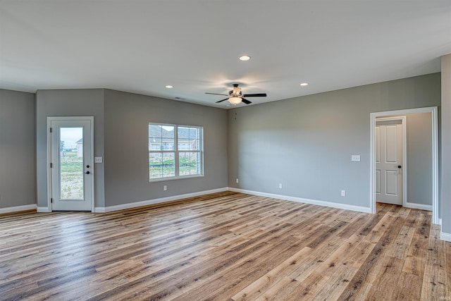 spare room with plenty of natural light, ceiling fan, and light wood-type flooring