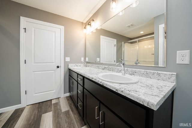 bathroom with vanity, walk in shower, and wood-type flooring