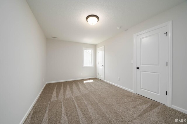 spare room with carpet and a textured ceiling