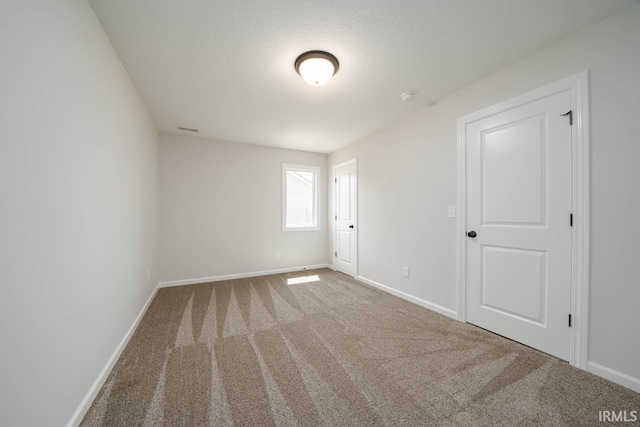 unfurnished room featuring carpet floors and a textured ceiling