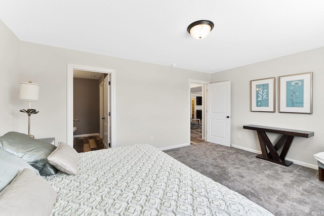 bedroom with ensuite bathroom and carpet flooring