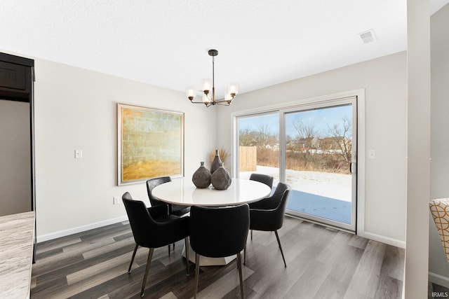 dining room with hardwood / wood-style floors and an inviting chandelier