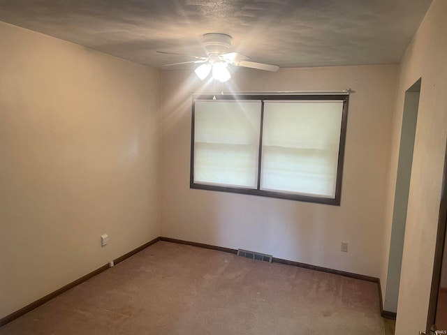 empty room with ceiling fan and carpet floors