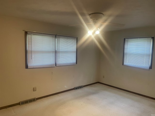 carpeted spare room featuring ceiling fan