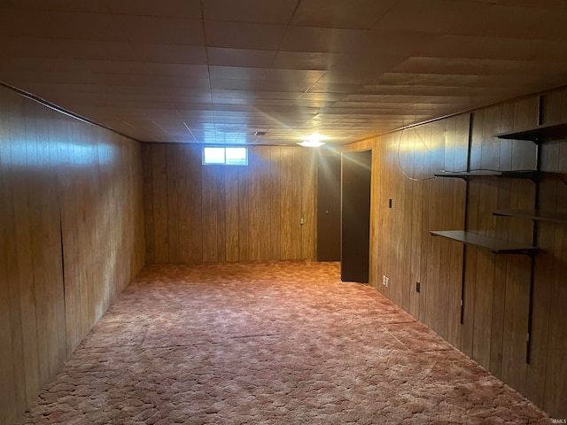 basement featuring wooden walls and carpet flooring