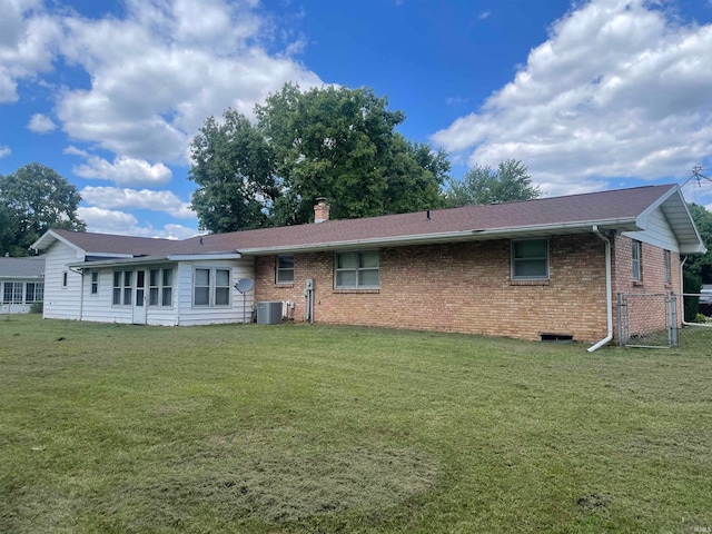 back of property featuring a yard and central air condition unit