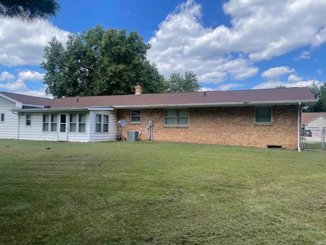 back of property featuring central AC unit and a yard