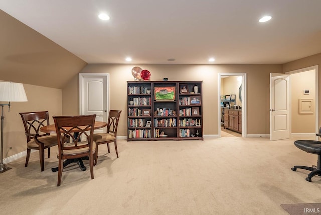 interior space with vaulted ceiling and light colored carpet