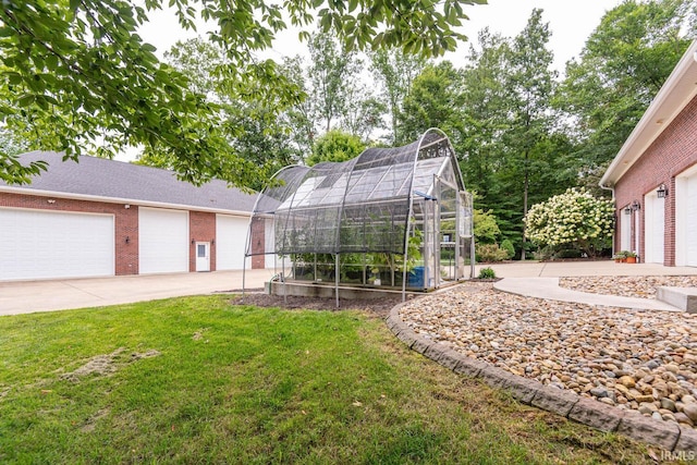 view of yard with a garage and an outbuilding