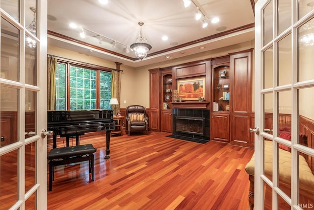 misc room with french doors, ornamental molding, a tray ceiling, a fireplace, and hardwood / wood-style floors