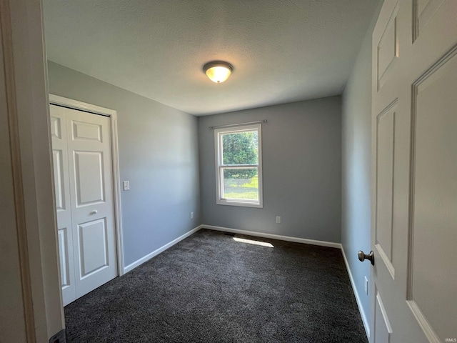 carpeted spare room featuring a textured ceiling