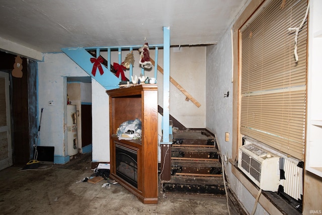 staircase with water heater and concrete flooring