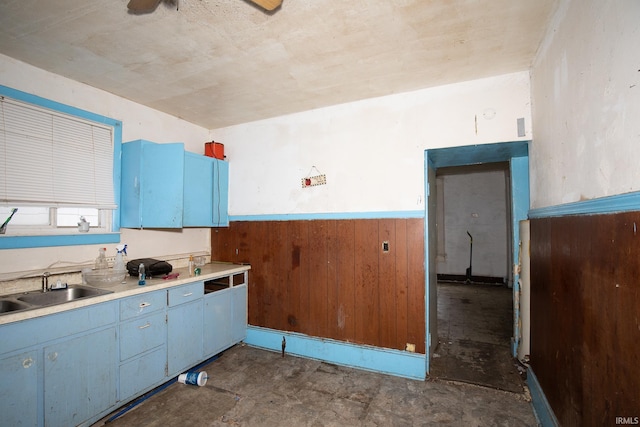 kitchen featuring blue cabinets, ceiling fan, and sink