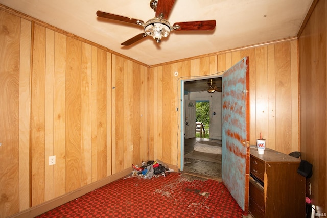 misc room with ceiling fan and wooden walls