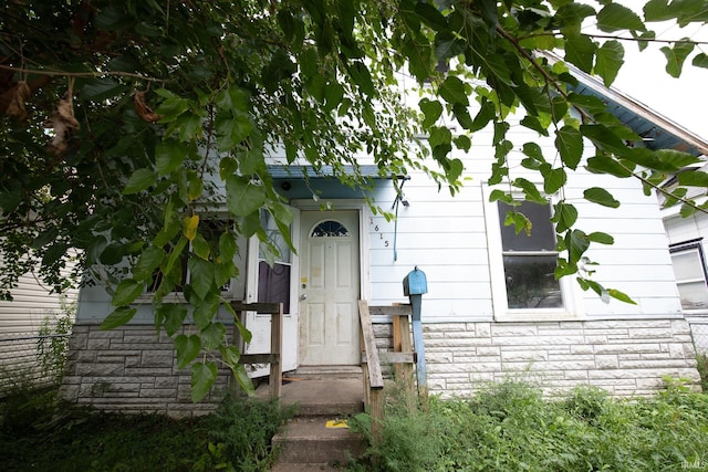 doorway to property with stone siding