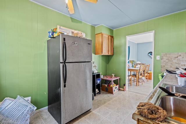 kitchen with ceiling fan, sink, light tile patterned floors, and stainless steel fridge