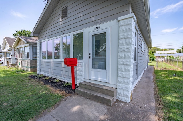 property entrance with a lawn