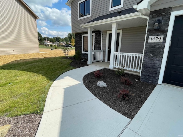 doorway to property with a lawn and a porch