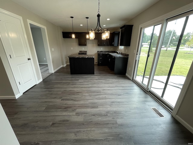 kitchen with a center island, an inviting chandelier, decorative light fixtures, sink, and wood-type flooring