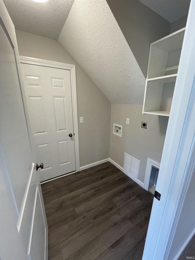 clothes washing area with dark hardwood / wood-style floors, a textured ceiling, washer hookup, and electric dryer hookup