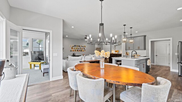 dining space with an inviting chandelier, sink, and hardwood / wood-style flooring