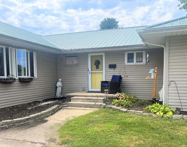 view of exterior entry with a lawn