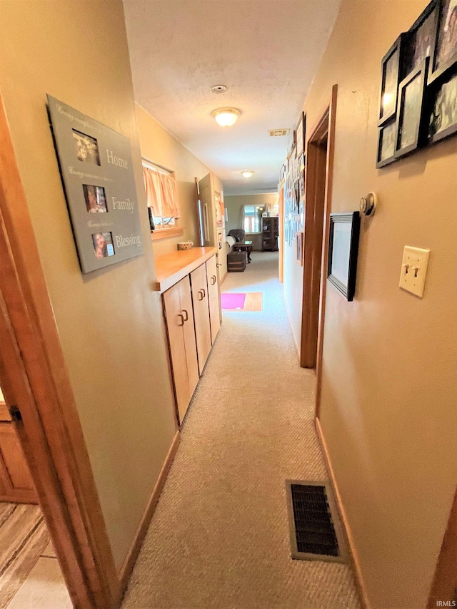 corridor with light colored carpet