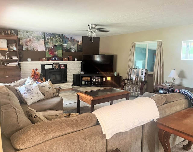 carpeted living room with ceiling fan, a textured ceiling, and a brick fireplace