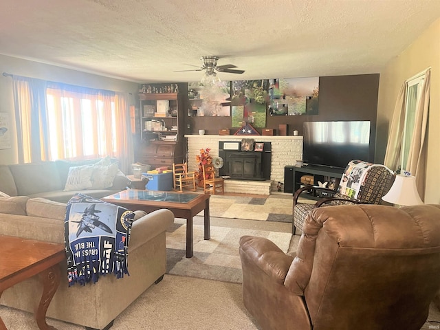 carpeted living room featuring a brick fireplace, a textured ceiling, and ceiling fan