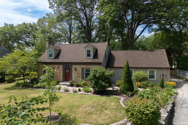 cape cod-style house with a front yard