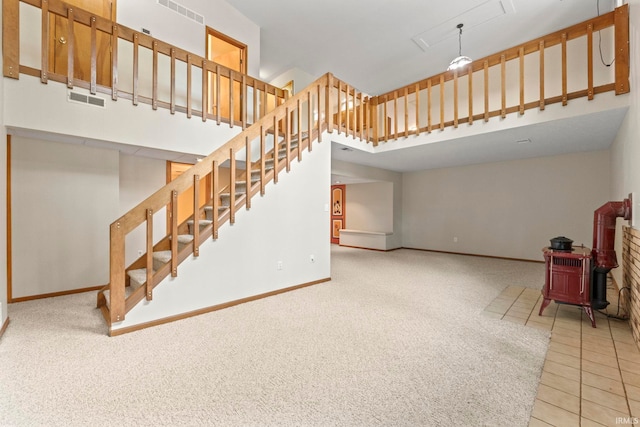 unfurnished living room with a high ceiling and light colored carpet