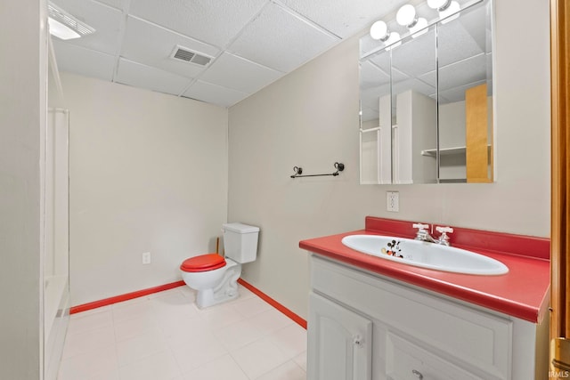 bathroom with tile patterned floors, vanity, a paneled ceiling, and toilet