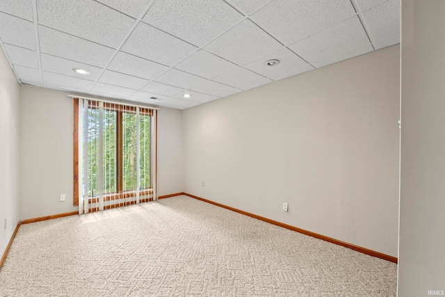 carpeted spare room featuring a paneled ceiling